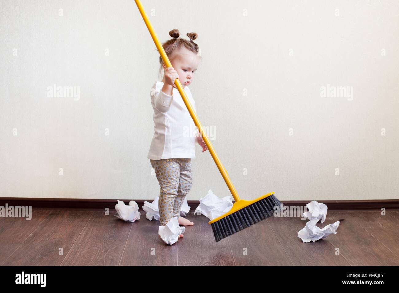 Kind sweeps Besen mit Papierkörbe in der Wohnung, im Haushalt  Stockfotografie - Alamy