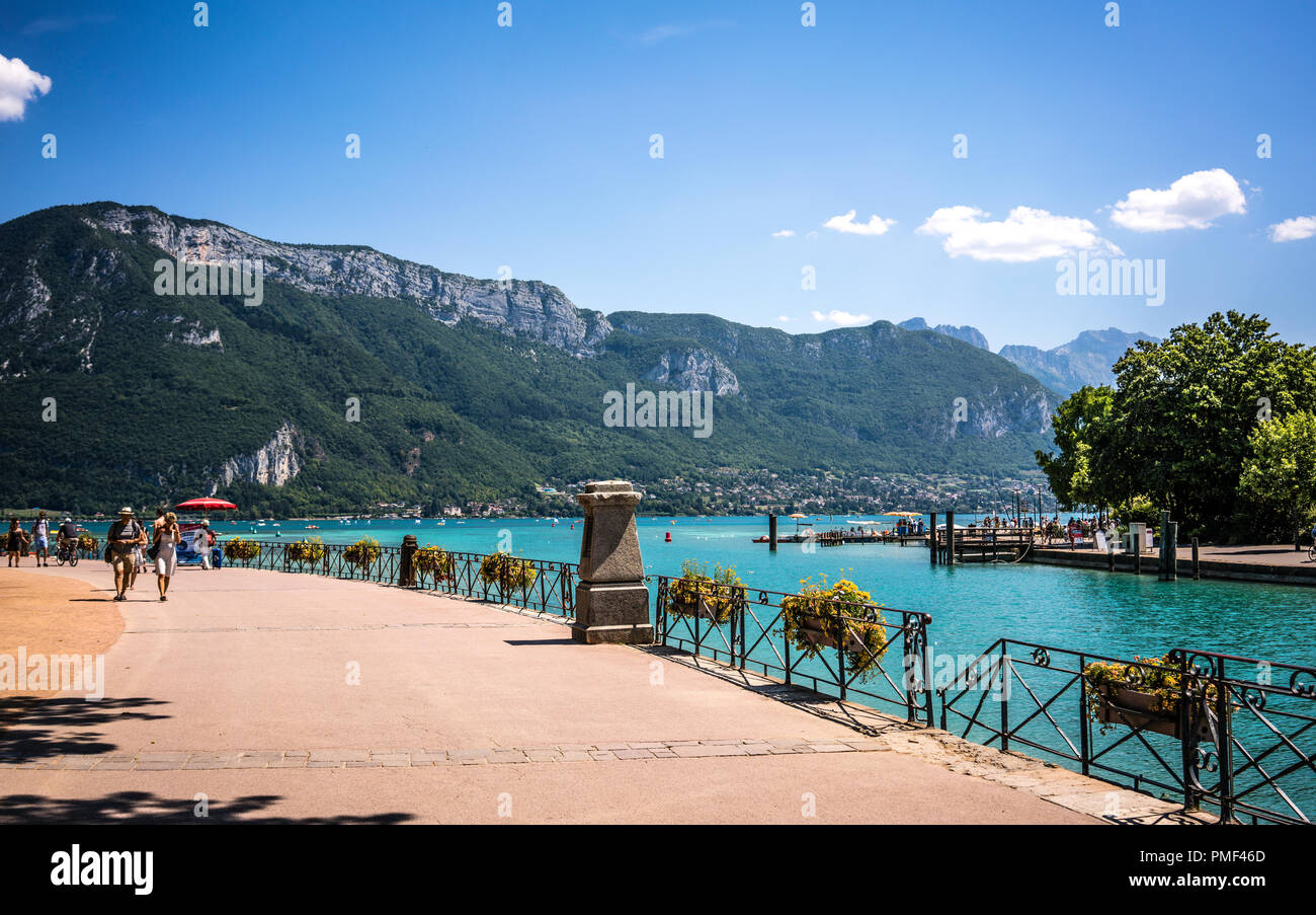 See von Annecy Bank und Bürgersteig mit Französischen Alpen Berge im Hintergrund Stockfoto