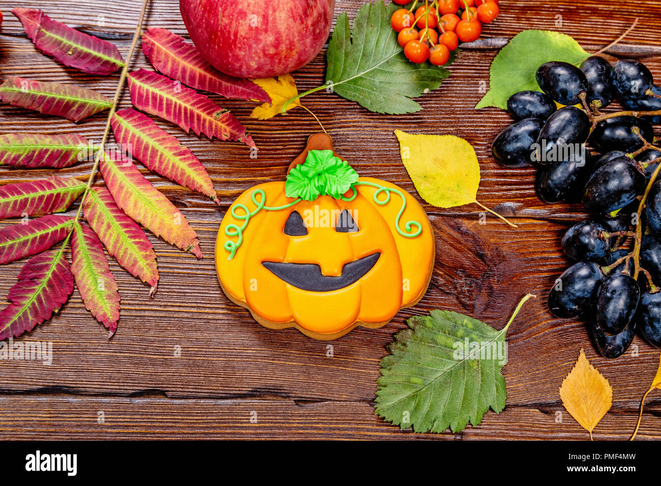 Schönen festlichen Hintergrund für Halloween mit Lebkuchen, Herbst Blätter, Beeren und Süßigkeit auf einen hölzernen Tisch. Freier Speicherplatz Stockfoto