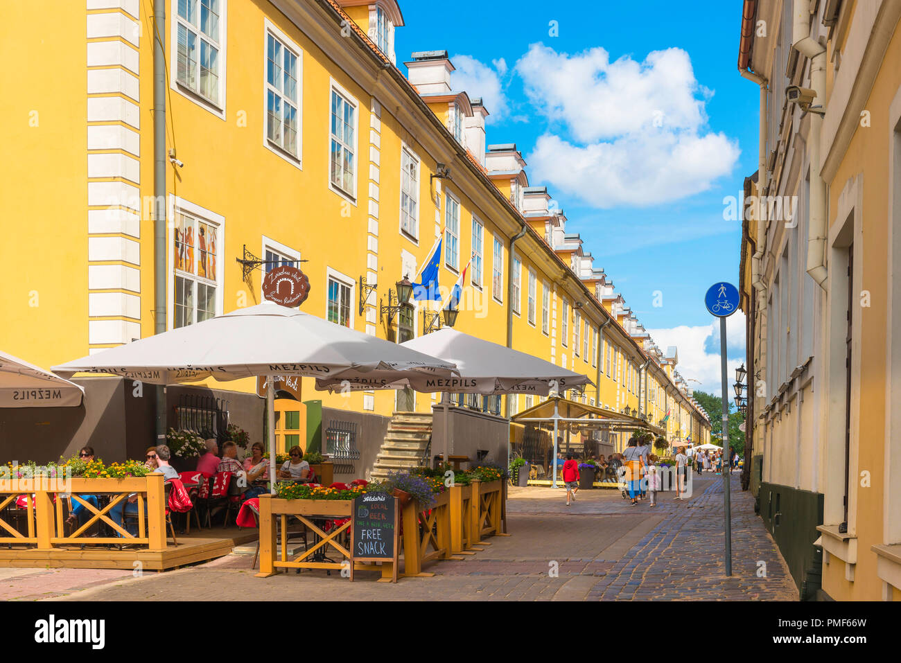 Riga Altstadt mit Blick auf ein Cafe Restaurant neben dem bunten Jacobs Kaserne Gebäude in Torna Iela in der historischen Altstadt von Riga, Lettland. Stockfoto