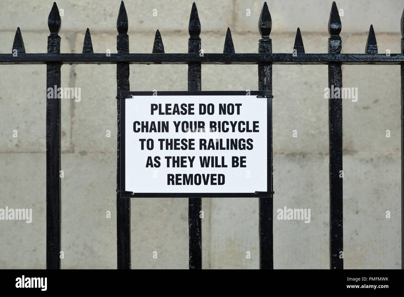 Zeichen zeigen ein Beispiel für schlechte Grammatik in Whitehall, wäre es besser lesen, wenn es hieß "Fahrrad angekettet an diese Geländer werden entfernt." Stockfoto