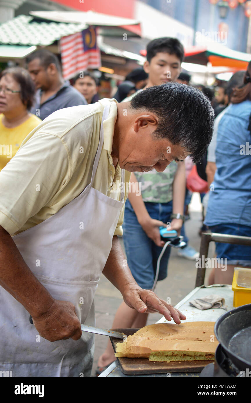 Kuala Lumpur, Malaysia - 9 September, 2017: Chinesische street Hersteller schneidet eine köstliche süße Kuchen mit Erdnüssen in den Straßen von Kuala Lumpur, Malaysia Stockfoto