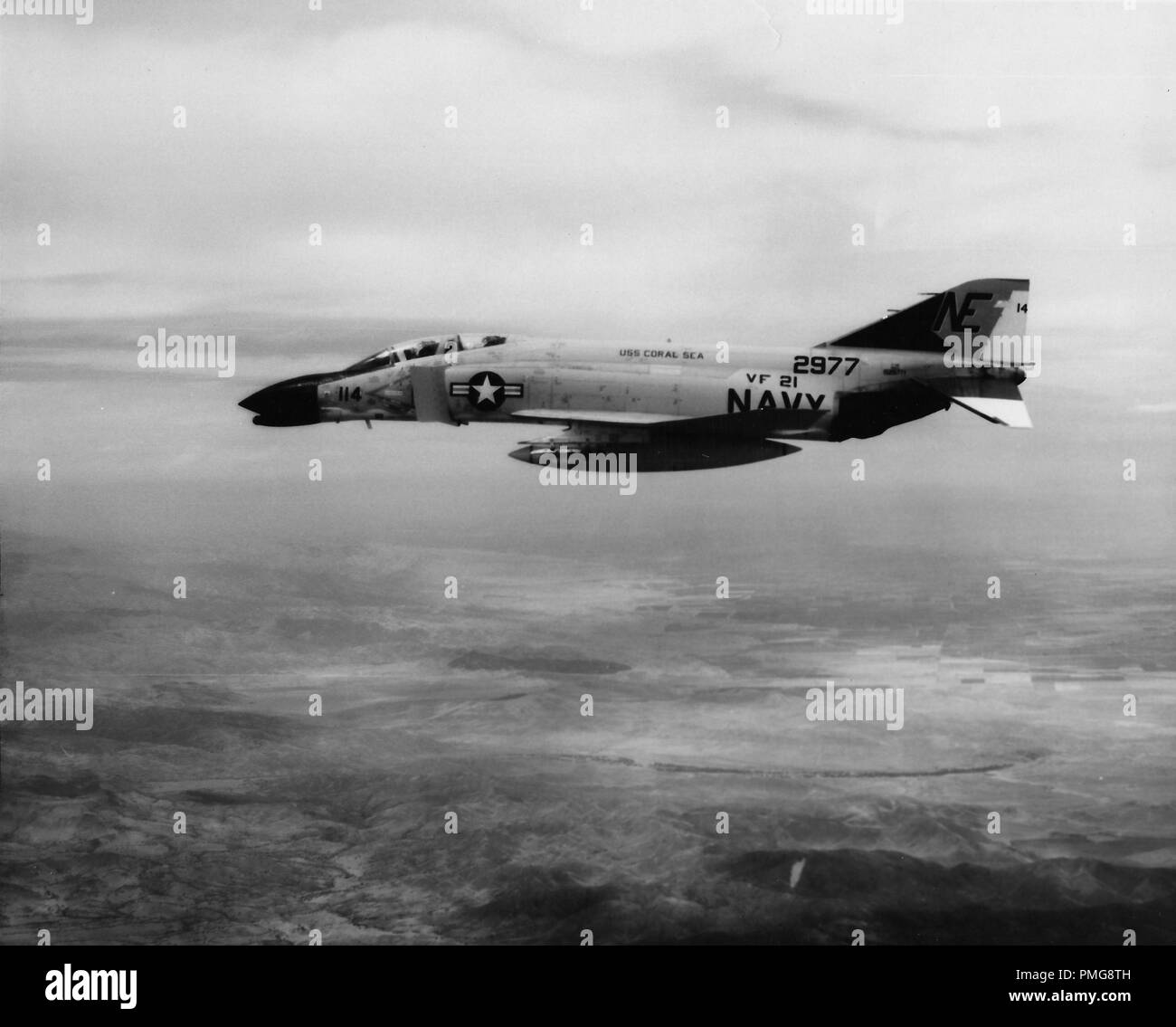 Schwarze und weiße Luftbild mit einem Profil anzeigen der United States Navy McDonnell Douglas F-4 Phantom II, im Flug, mit den Ziffern '114' auf der Nase", 2977 "in der Nähe von seinem Schwanz, und die Worte "USS Coral Sea' auf seinen Körper, während des Vietnam Krieges, 1965 fotografiert. () Stockfoto