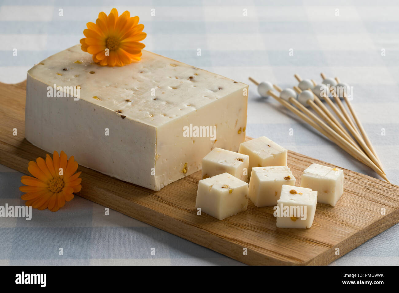 Ziegen Käse und Würfel mit Koriander und Bockshornkleesamen mit essbaren Pot marigold Blumen dekoriert Stockfoto