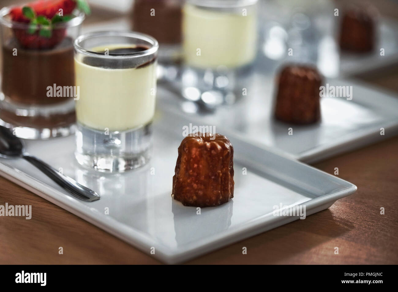 Französische Kuchen cannele auf einem Teller und Vanille Creme Stockfoto