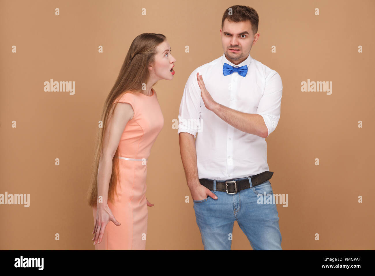Oh bitte stoppen. verwirrt Mann im weißen Hemd versuchen zu verbieten, Block oder wütende Frau in rosa Kleid, die nervös stoppen, kreischend an ihn schreien. indoor Studio s Stockfoto
