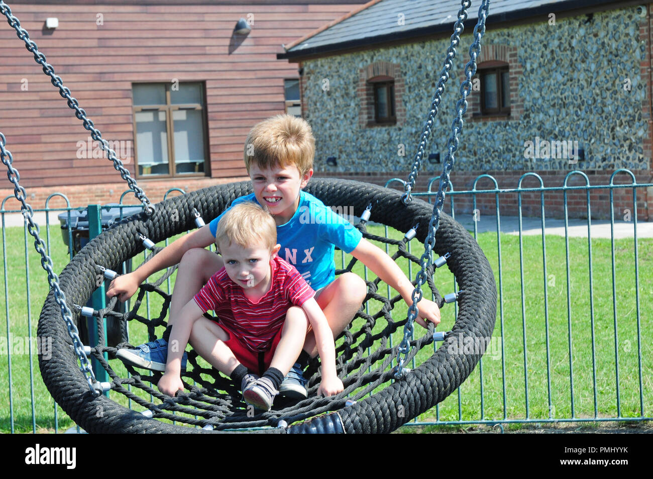 Zwei kleine Jungen auf einer kreisförmigen schwingen in einem Spiel Park Stockfoto