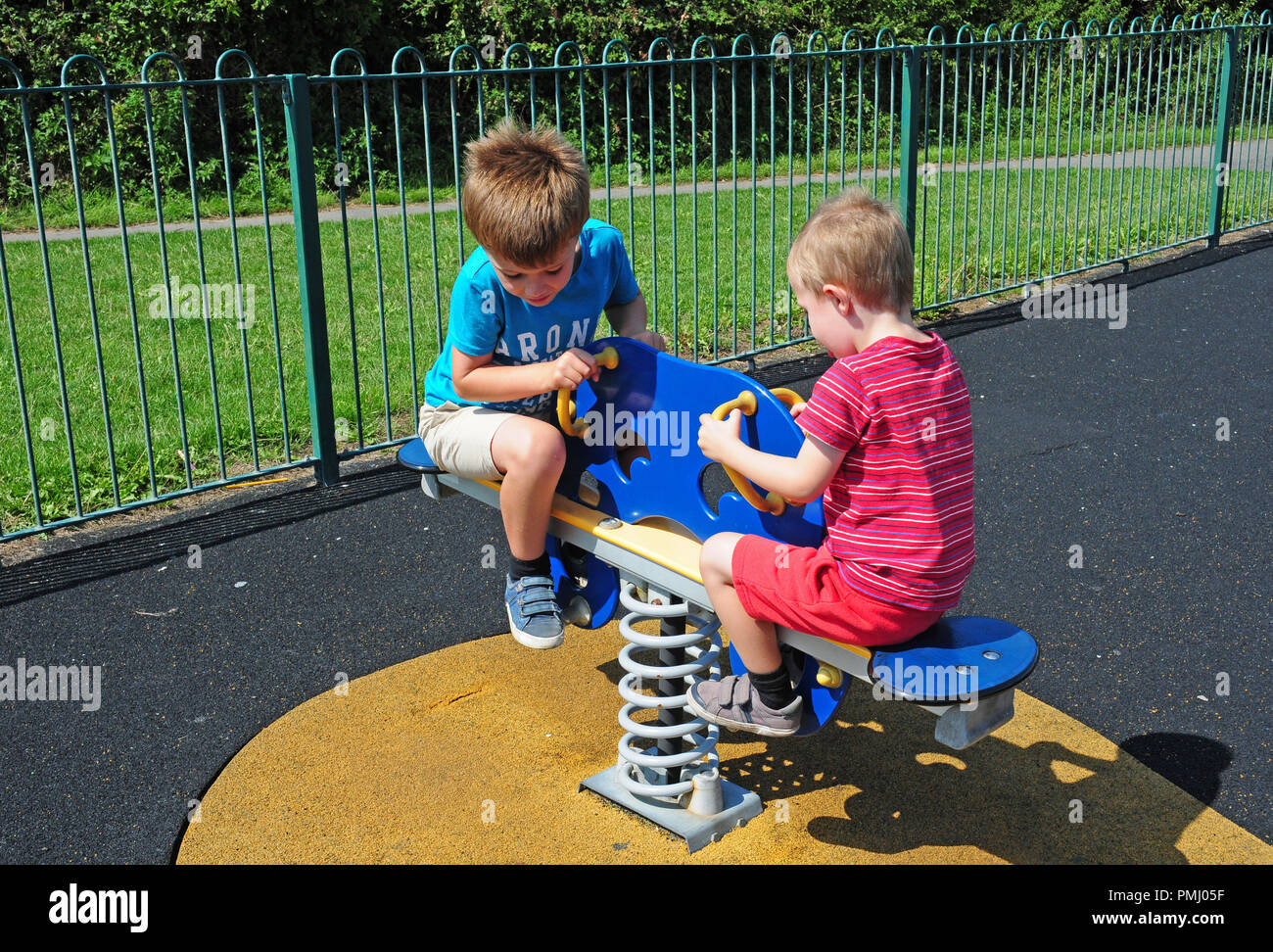 Zwei kleine Jungen spielen auf einer Wippe in einem Spiel Park. Stockfoto