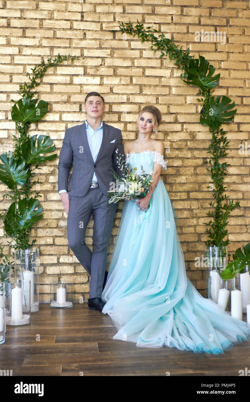 Neu verheirateten Paar, Paar vor der Hochzeit. Der Mann und die Frau  einander zu lieben. Die Braut im Türkis Kleid und der Bräutigam in einem  blauen Anzug. Wir Stockfotografie - Alamy