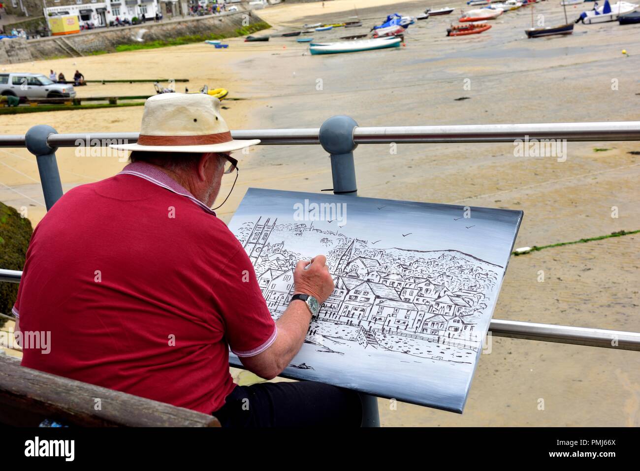 Ein Mann skizzieren eine Zeichnung auf St Ives, Cornwall, England, Großbritannien Stockfoto