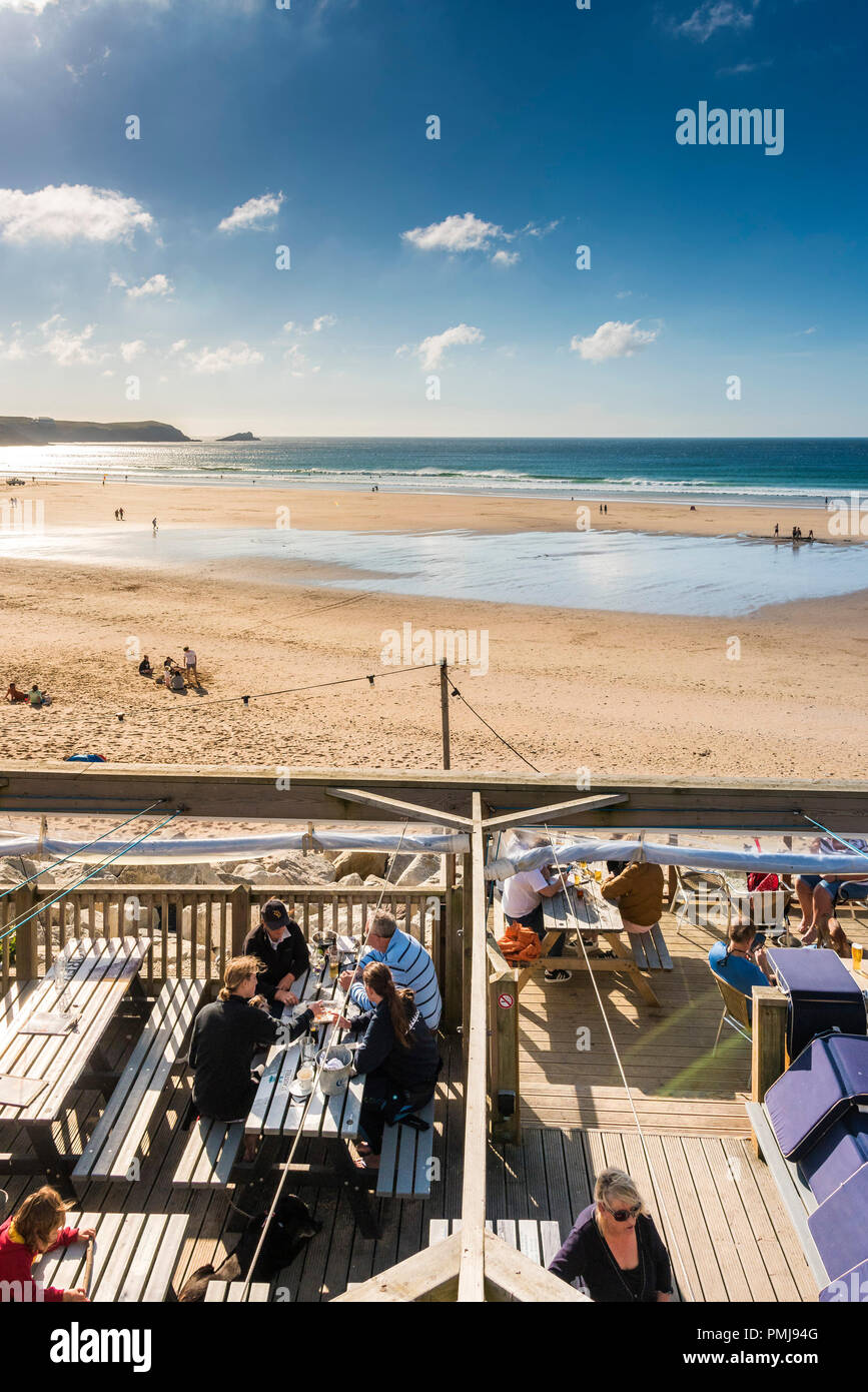 Urlauber entspannen an einem sonnigen Abend an Fistral Beach in Newquay in Cornwall. Stockfoto