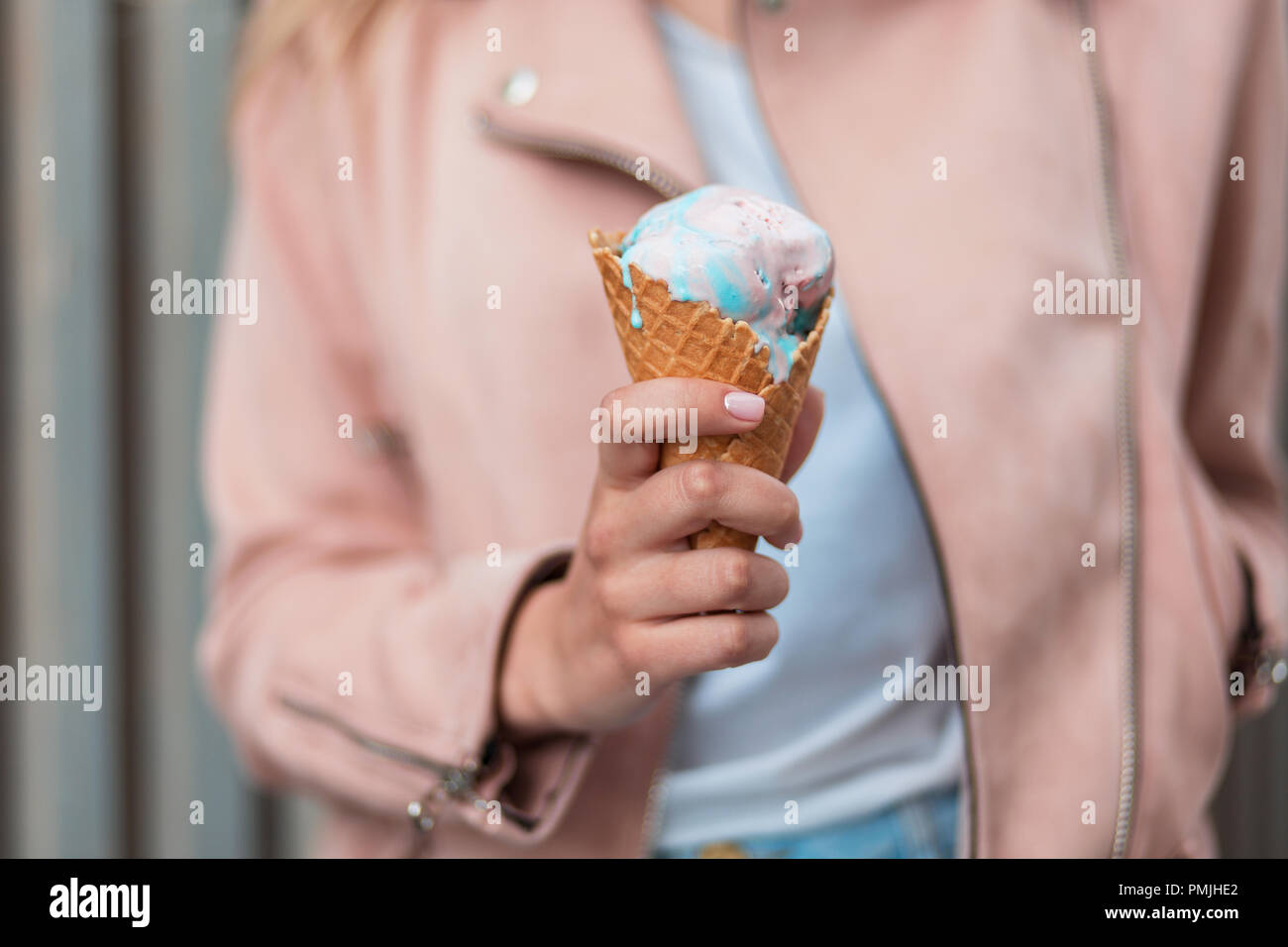 Köstliche rosa und blau Eis. Mädchen hält einen Wafer Kegel mit Eis Stockfoto