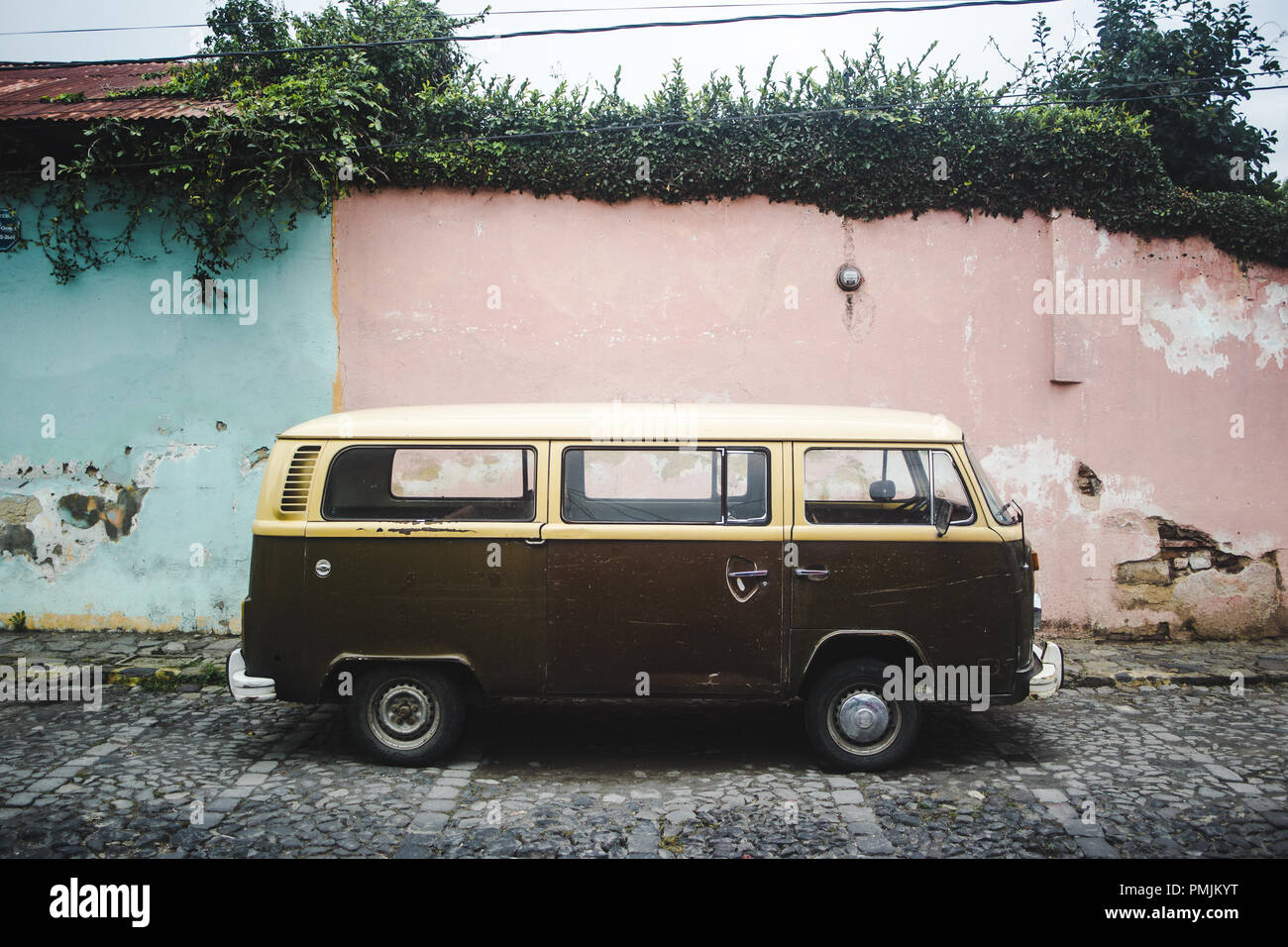 Braun und Creme retro Wohnmobil aus den 1970er Jahren entlang einer Straße mit Kopfsteinpflaster mit Pastell rosa und blaue Wände geparkt Stockfoto