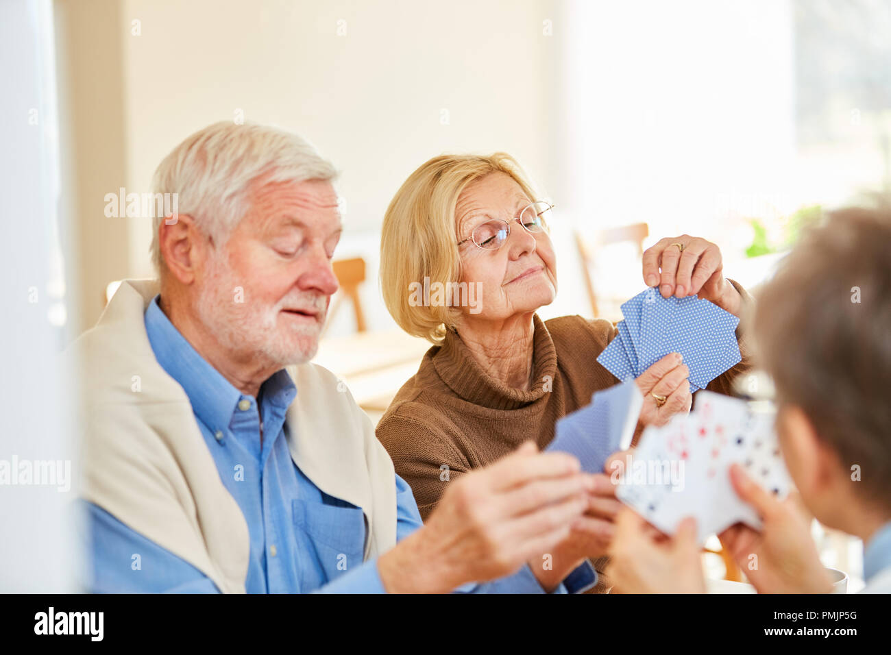 Senior Paar spielen und Freunde, die gemeinsam im Altenheim oder zu Hause Stockfoto