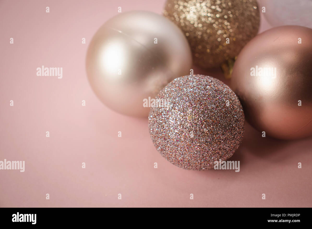 Rose Gold Weihnachtskugeln auf einem rosa Hintergrund Stockfotografie