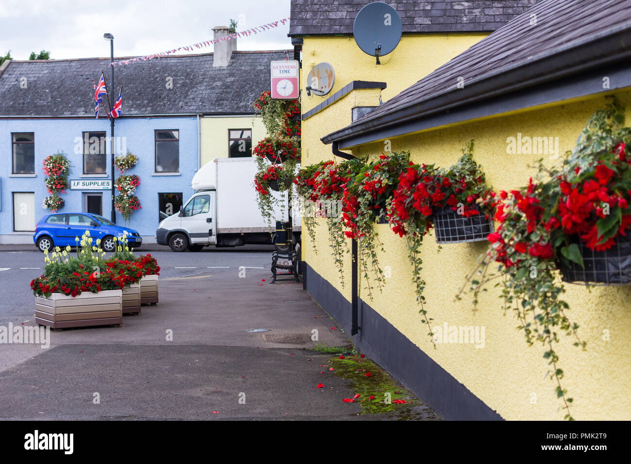 Hängenden Blumenkörben und Blumenbeete im kleinen Dorf, Broughshane, County Antrim, Nordirland. Stockfoto
