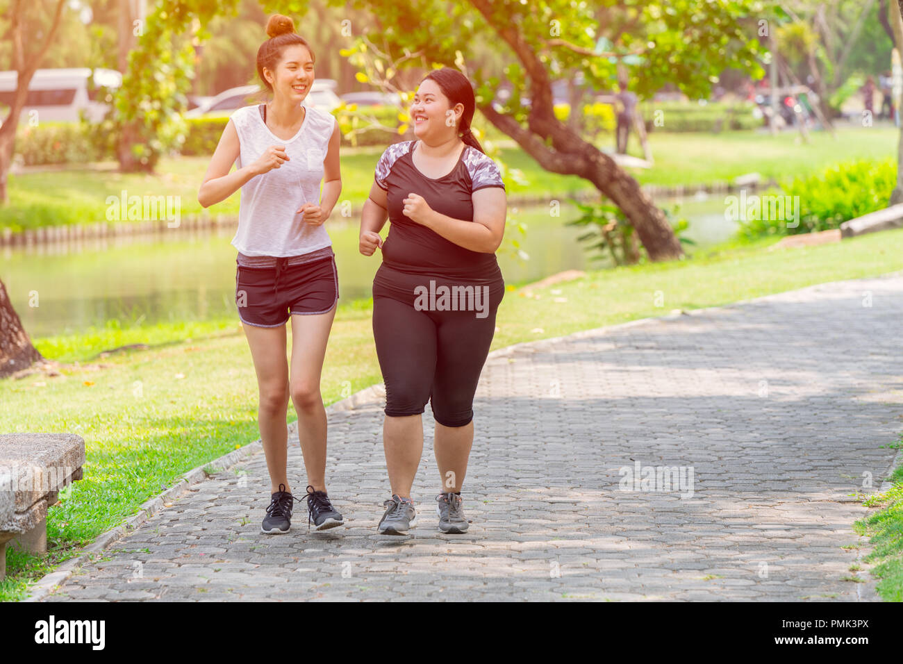 Asiaten zwei Thin und fat Girls Freund laufen joggen Park am Morgen im Freien Stockfoto