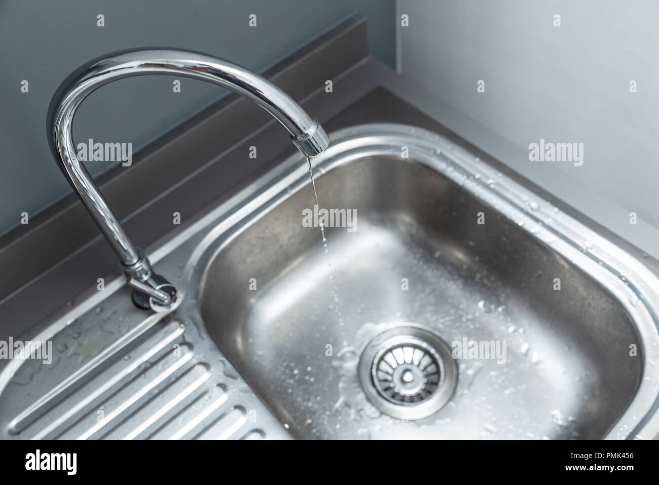 Wasser lange Reichweite Mischbatterie mit Wassertropfen Leck am Waschbecken Waschbecken Leitungswasser zu verschwenden Stockfoto