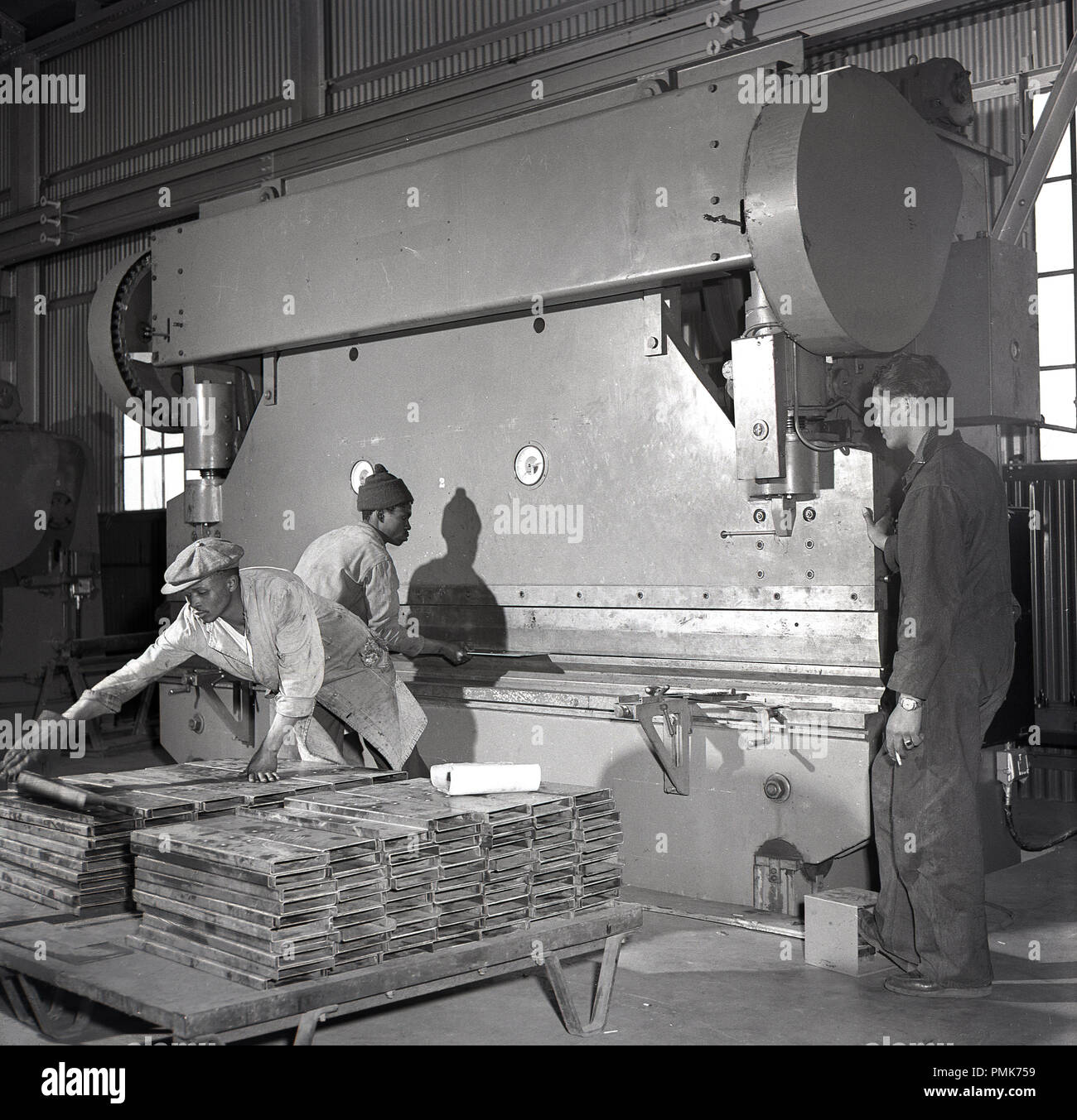 1950, historische, Arbeiter in einer mit einem großen Maschine Process Factory und kompakte oder Konzentrat abgebaute Uranerz, Niger, Afrika. Uran ist ein wichtiger Energie Mineral - für die Herstellung von Elektrizität genutzt - und wird gefördert, und wie andere ähnliche Metalle konzentriert. Stockfoto