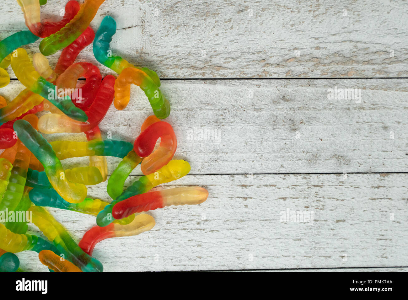 Stapel bunter Gummibärchen Worms auf einem hölzernen Hintergrund Stockfoto