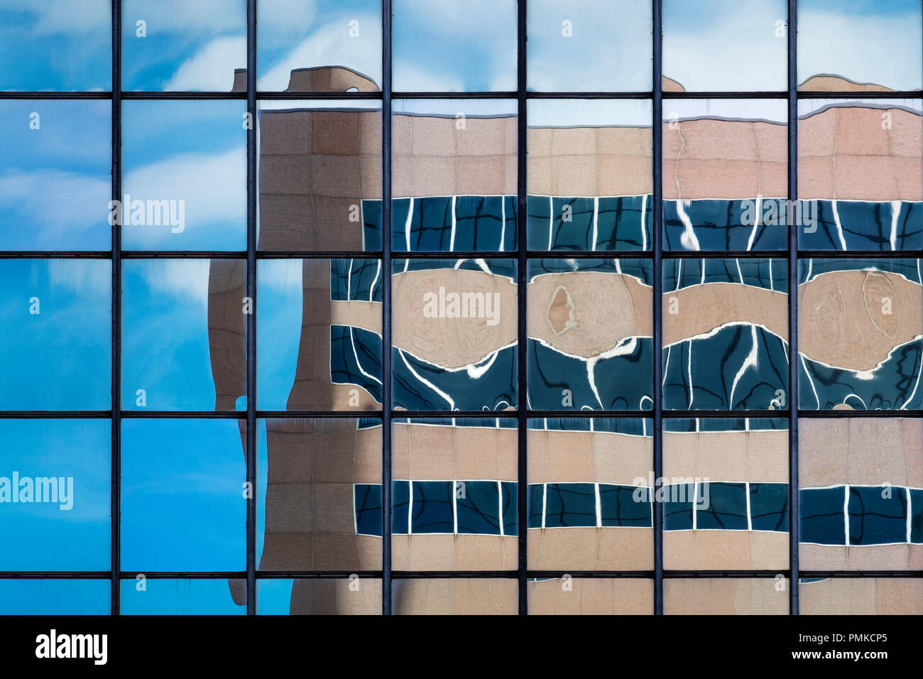 Architektur Detail in Bürogebäude, Birmingham, Alabama. Eine verzerrte Widerspiegelung eines Bürogebäudes in der reflektierenden Fenstern von einem anderen Büro blockieren. Stockfoto