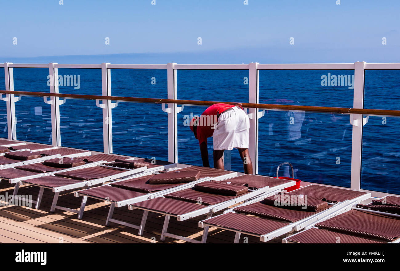 Besatzungsmitglied, das Tragen der roten und weissen Uniform, bücken vor einem blauen Meer Hintergrund, auf Kreuzfahrtschiff MSC Seaview Stockfoto