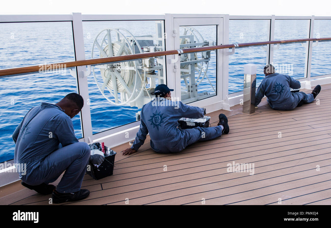 Drei Besatzungsmitglieder, Malerei Metallarbeiten, auf Kreuzfahrtschiff MSC Seaview Stockfoto