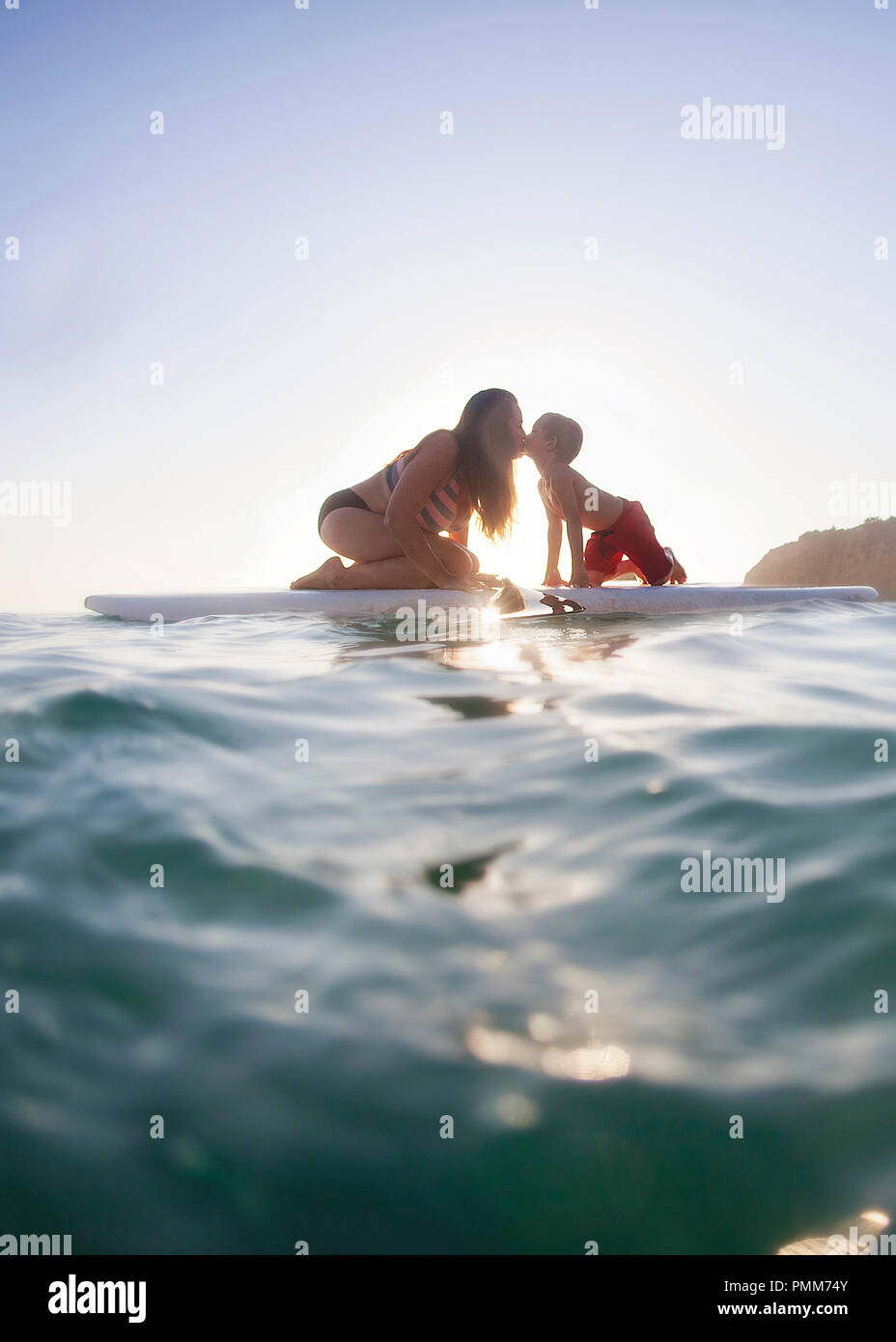 Mutter und Sohn sitzen auf paddleboard Küssen, Orange County, Kalifornien, USA Stockfoto