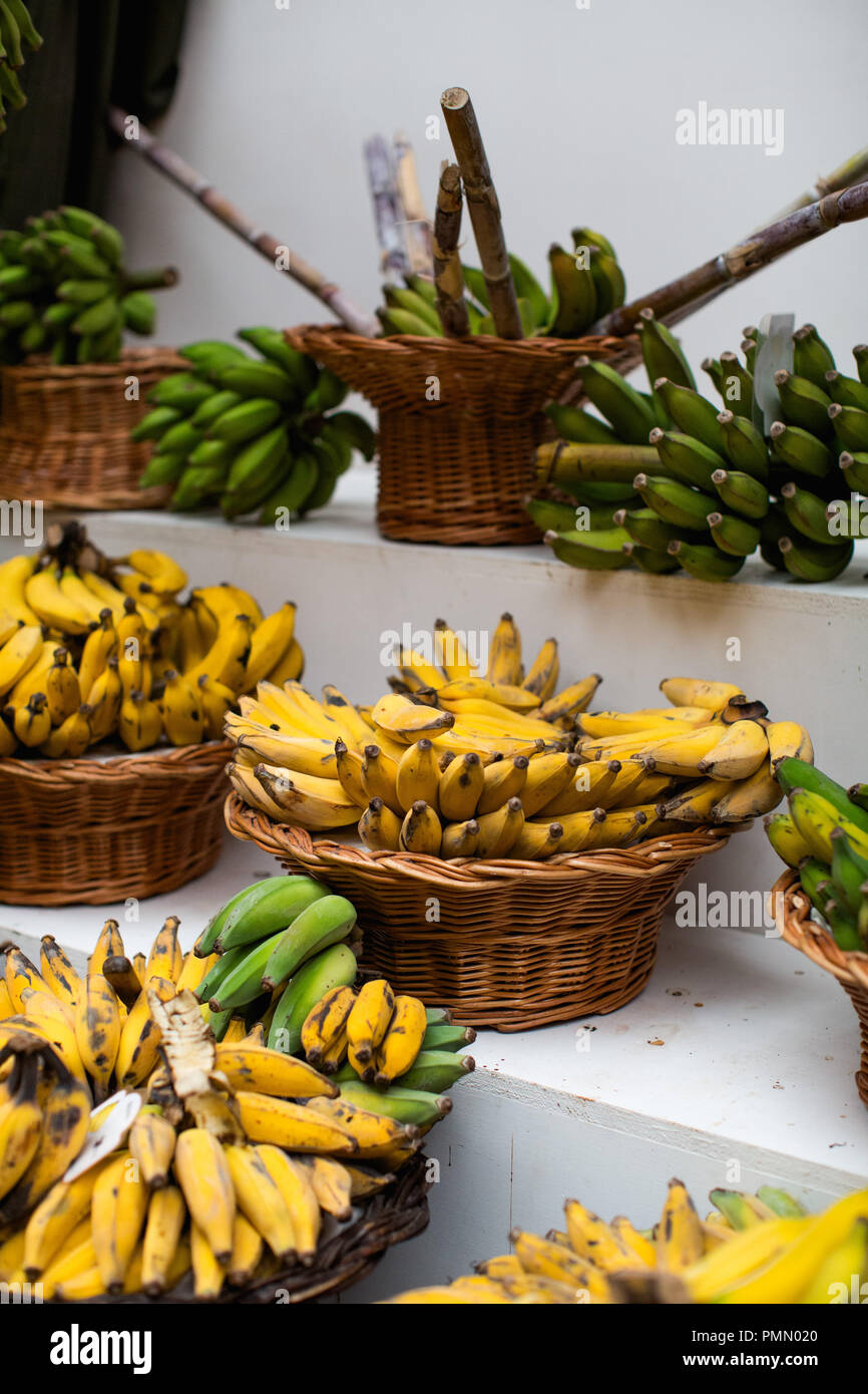 Schalen von reife, gelbe Bananen in der traditionellen Körbe angezeigt auf einem Marktstand in Mercado dos Lavradores in Funchal. Stockfoto
