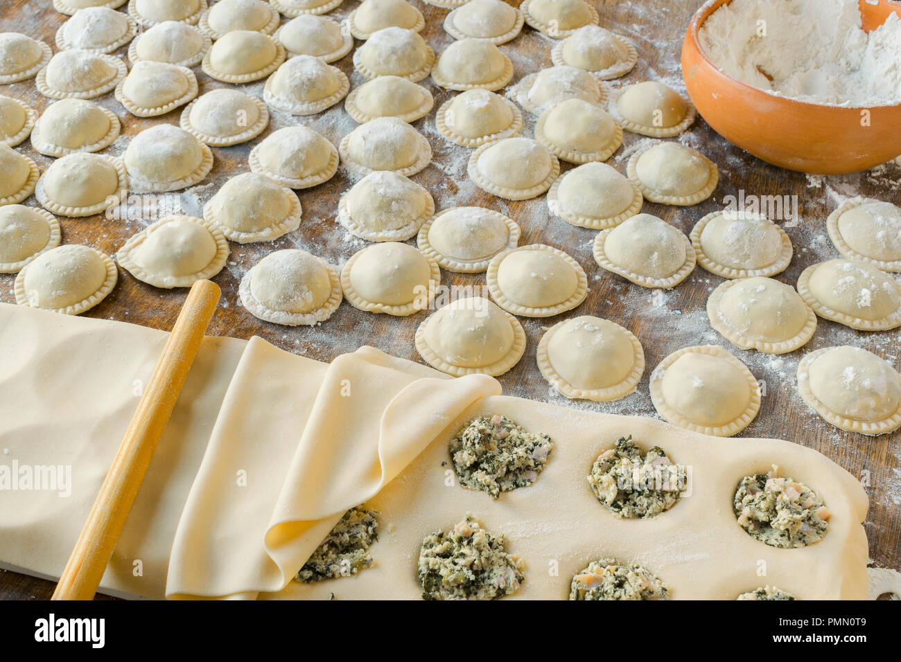 Die hausgemachten Nudeln: Der Teig zubereitet und geknetet, gefüllt mit Käse, Ricotta, Mangold und Schinken, große runde Ravioli (Sorrentino) vorbereitet und lesen Stockfoto