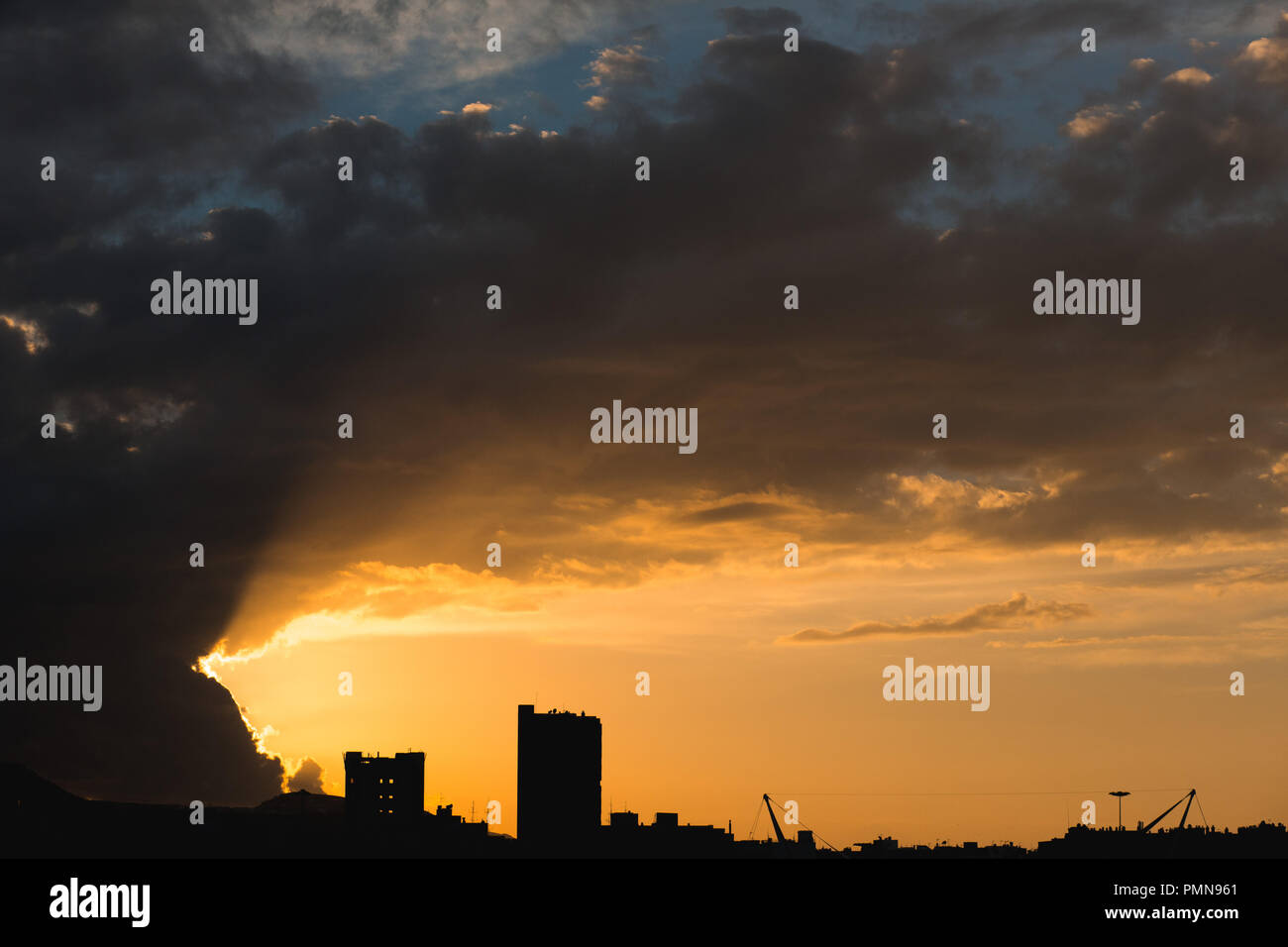 Dramatischer Sonnenuntergang über eine moderne Stadt mit Hochhaus Hochhäuser am Horizont die Silhouette Stockfoto