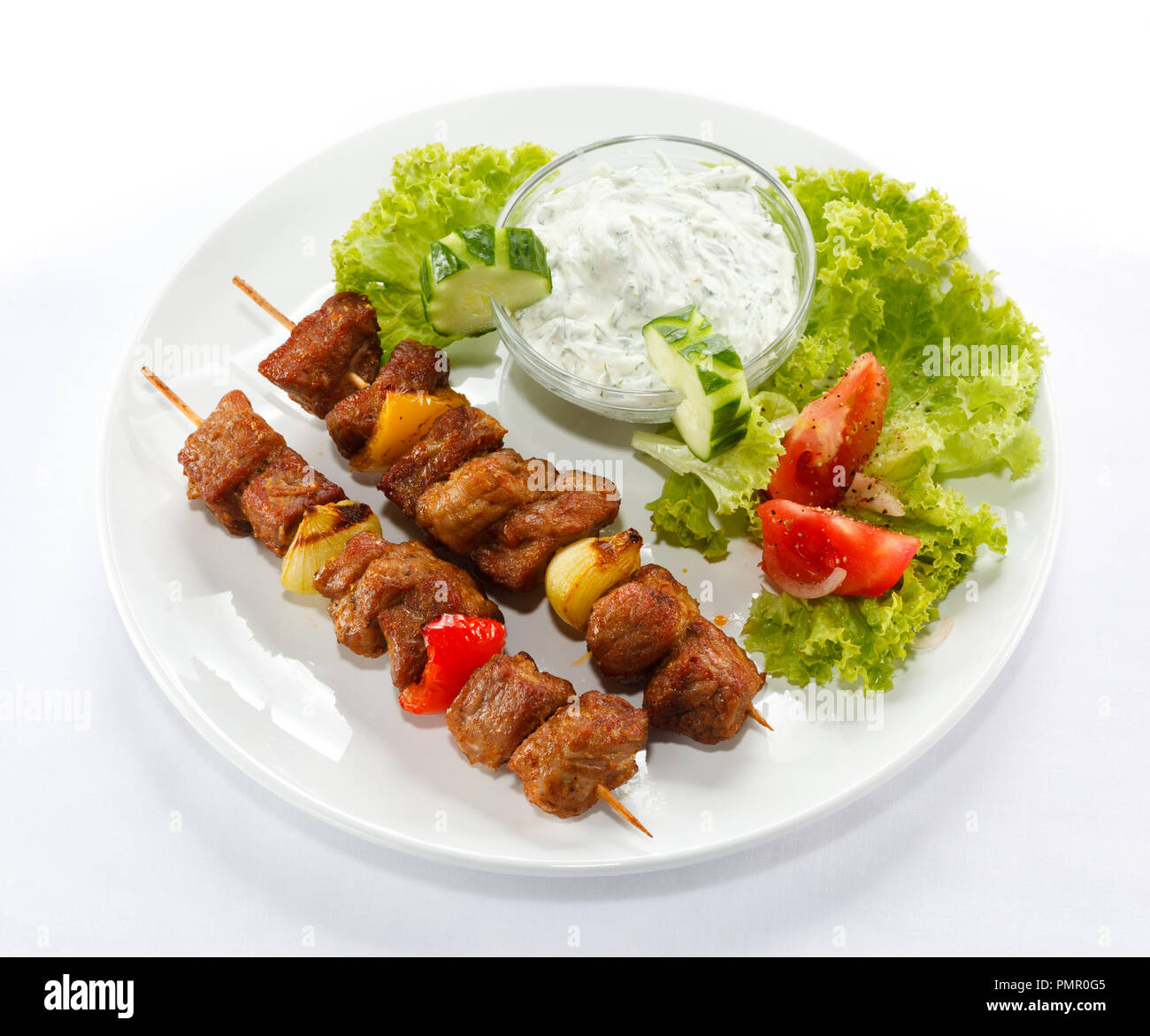 Fleisch und Gemüse vom Grill auf Feuer isoliert auf weißem Stockfoto