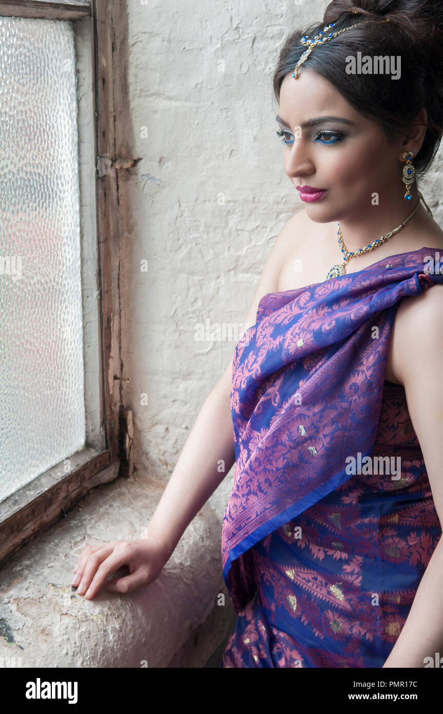 Schöne indische Frau Blick aus Fenster Stockfoto
