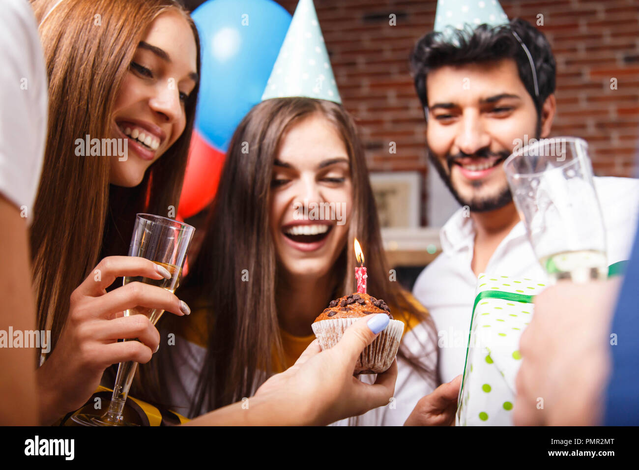 Awesome brunette Geburtstag Mädchen in einer Partei hat Lachen und immer bereit, die Kerzen auf dem Kuchen auszublasen Stockfoto