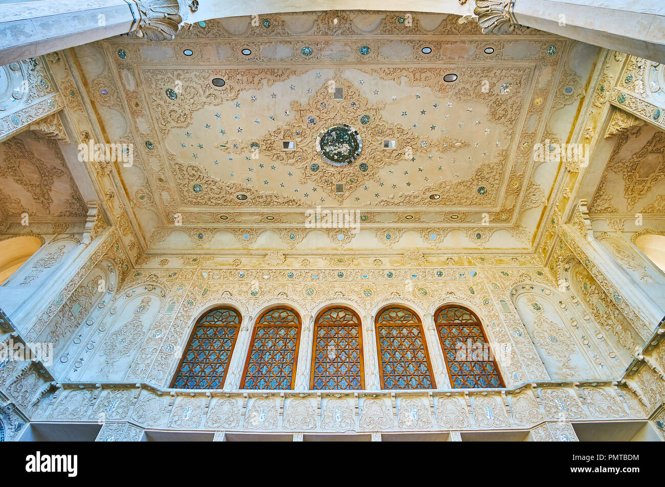 KASHAN, IRAN - Oktober 22, 2017: Die floralen Mustern der geschnitzten Stuck und fein mirrorwork an der Decke und den Wänden der Sommerterrasse in Tabatabaei Hou Stockfoto