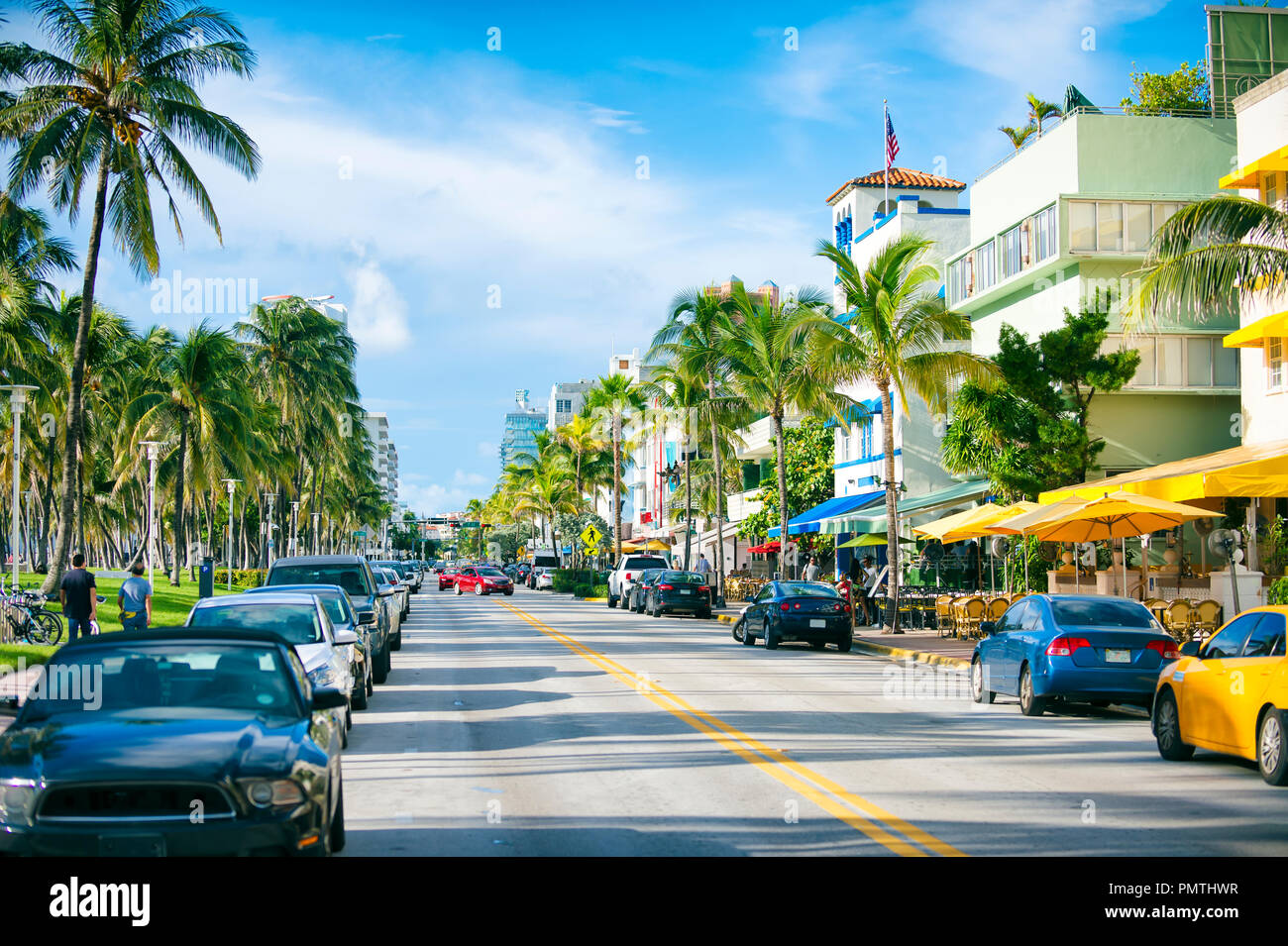 Am frühen Morgen Blick hinunter Ocean Drive mit Palmen und Art déco-Hotel in South Beach. Stockfoto