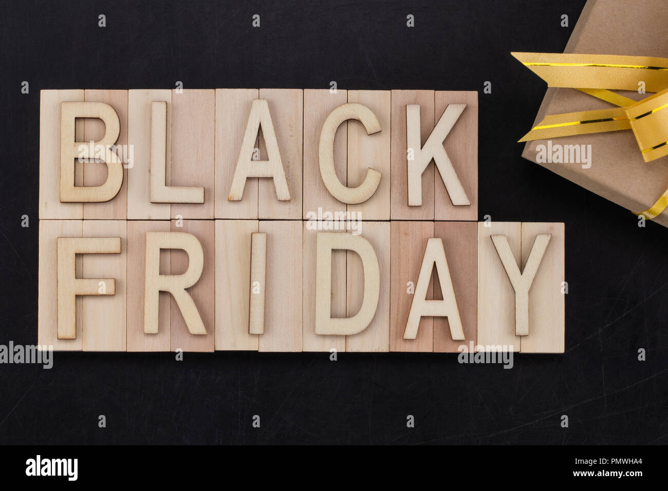 Schwarzer Freitag - Text in Holz- Buchstaben auf der Tafel mit Geschenk. Kopieren Sie Platz. Stockfoto