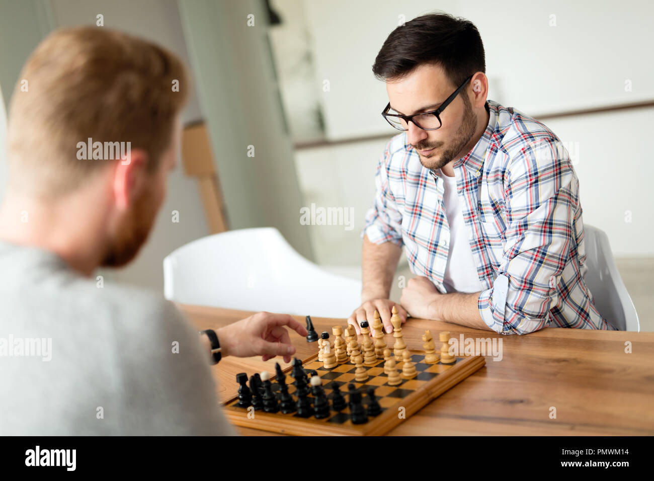Zwei junge Mann spielt Schach zu Hause Stockfoto