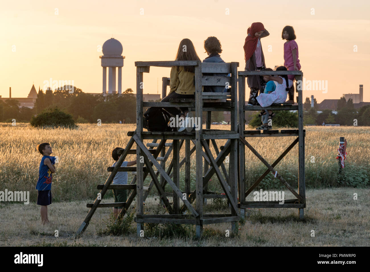 Kinder beobachten Sonnenuntergang am ehemaligen Flughafen Tempelhof, Berlin Stockfoto