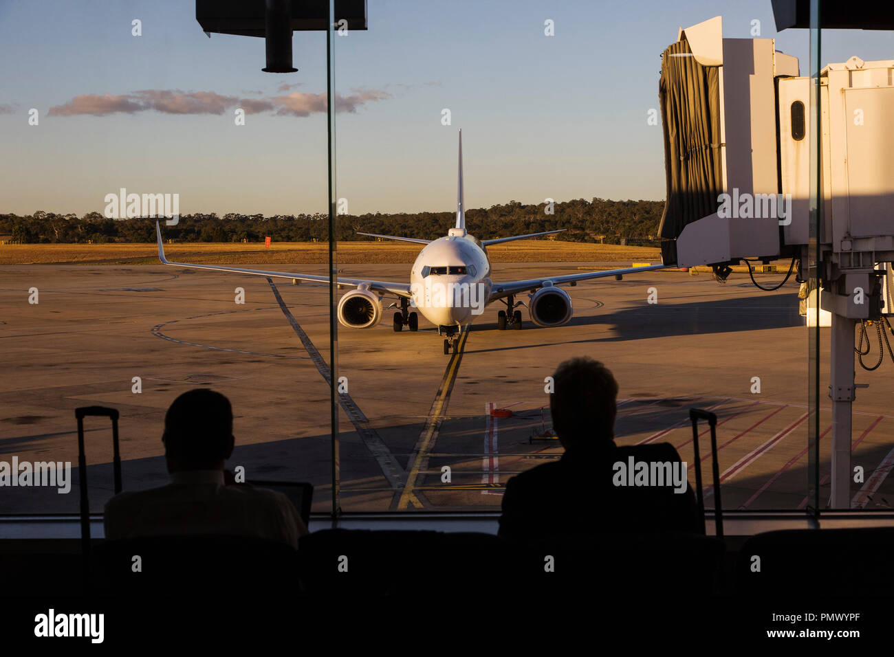 Flugzeug nähert sich Fluggastbrücke am Flughafen Stockfoto
