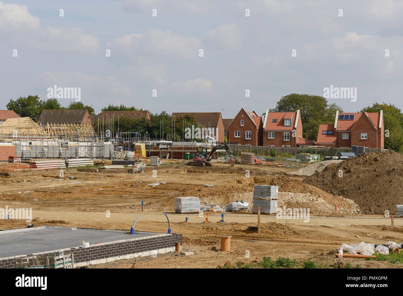 Abgeschlossen Häuser und Häuser im Bau auf einer Wohnsiedlung in Norfolk, Großbritannien Stockfoto
