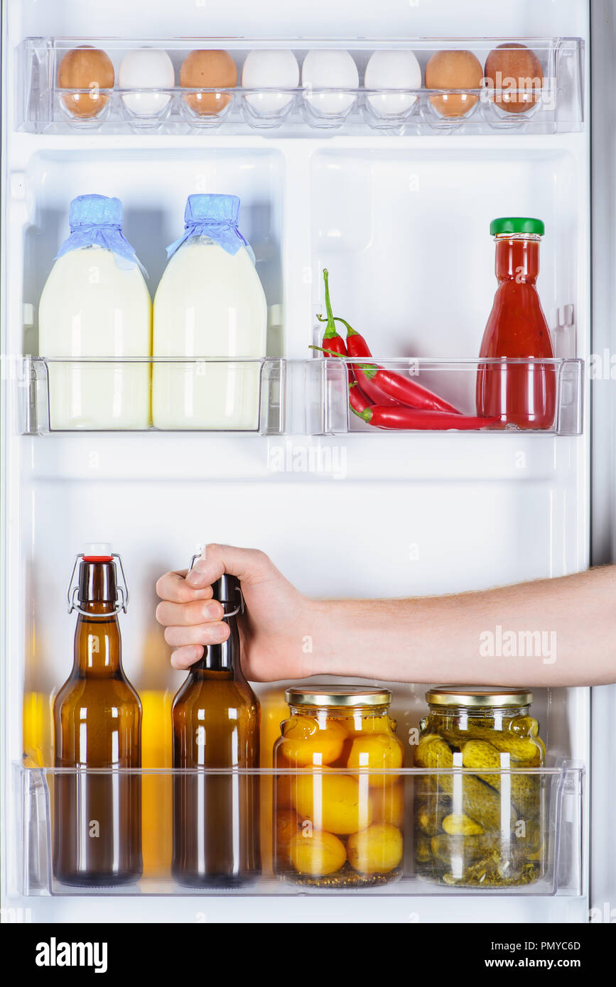 Zugeschnittenes Bild des Menschen nehmen eine Flasche Bier aus dem Kühlschrank Stockfoto