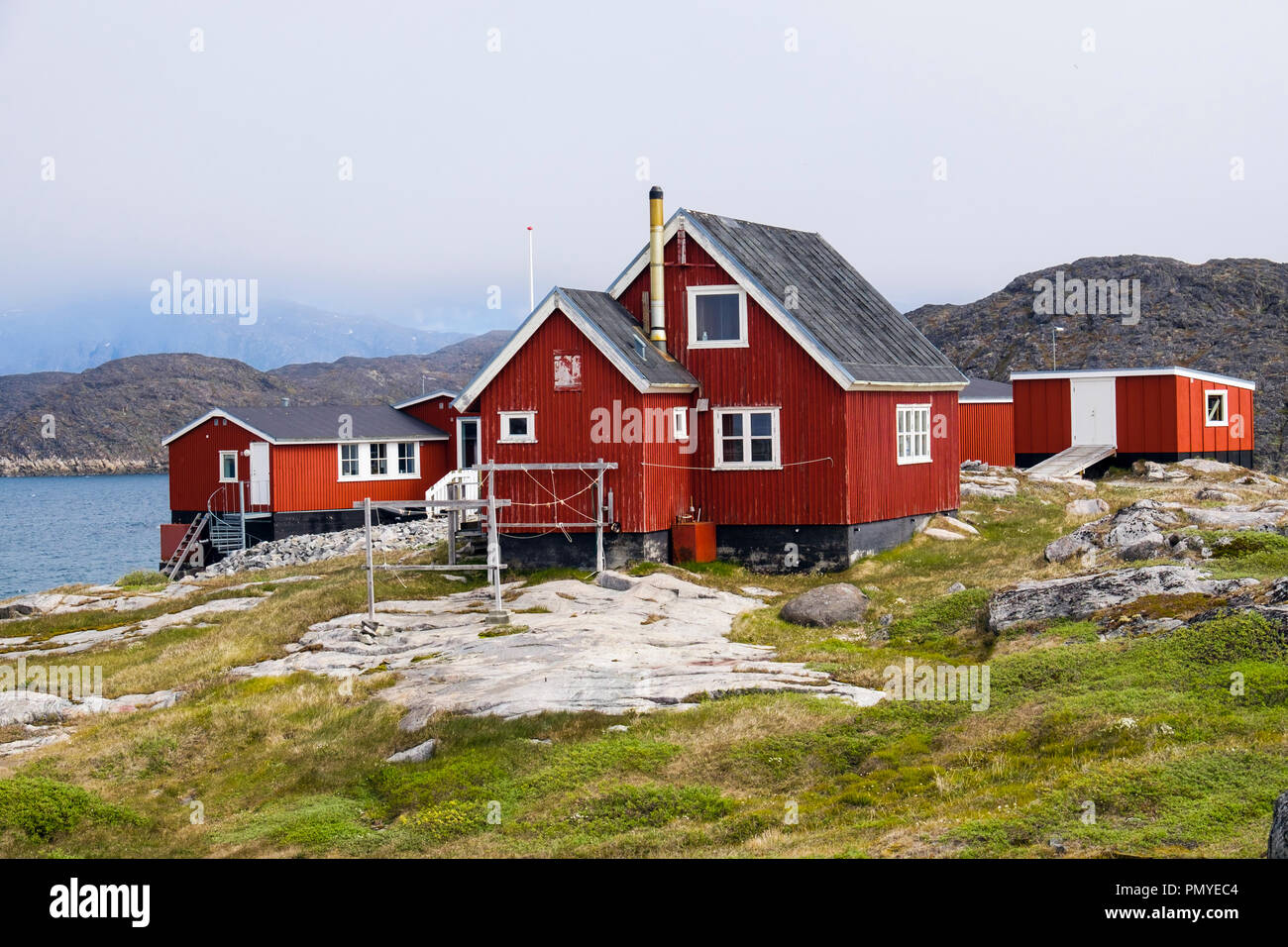 Typische Inuit Dorf Holzhäuser rot lackiert auf Meer. Itilleq, Qeqqata, Grönland. Auf einer kleinen Insel 2 km nördlich des Polarkreises Stockfoto