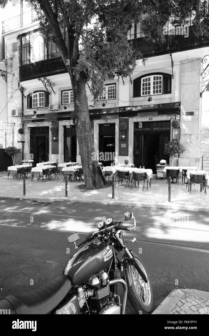 Klassische grüne Triumph Motorrad gegenüber einem traditionellen portugiesischen Lissabon Restaurant geparkt Stockfoto