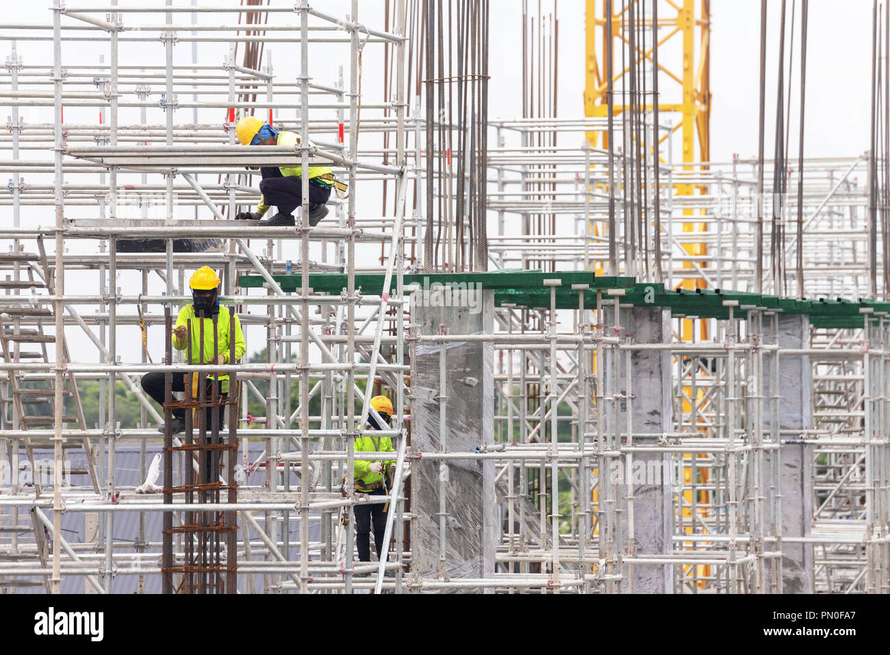 Asiatische Bauarbeiter arbeiten auf Gerüsten von Gebäude Baustelle in der Stadt. Urban expansion in der Hauptstadt von Asien wachsen schnell Stockfoto