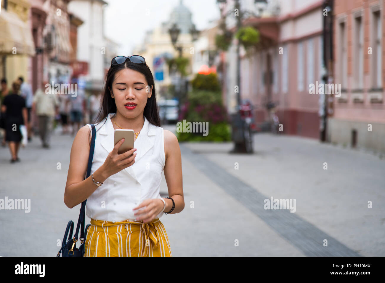 Asiatische Mädchen mit einem Smart Phone auf der Straße Stockfoto