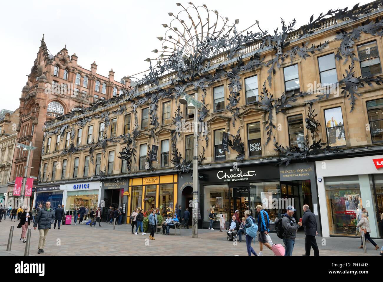 Das Metallkunstwerk aus Pfauenfedern schmückt das Gebäude des Princes Square an der Buchanan Street, an dem Menschen in Glasgow, Schottland, vorbeilaufen Stockfoto