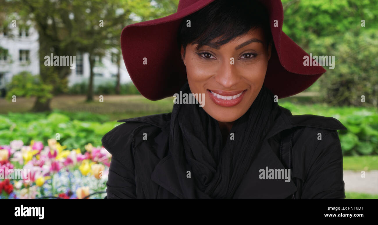 Schöne junge afrikanische Frau glücklich im schönen Garten im Freien in Brügge Stockfoto