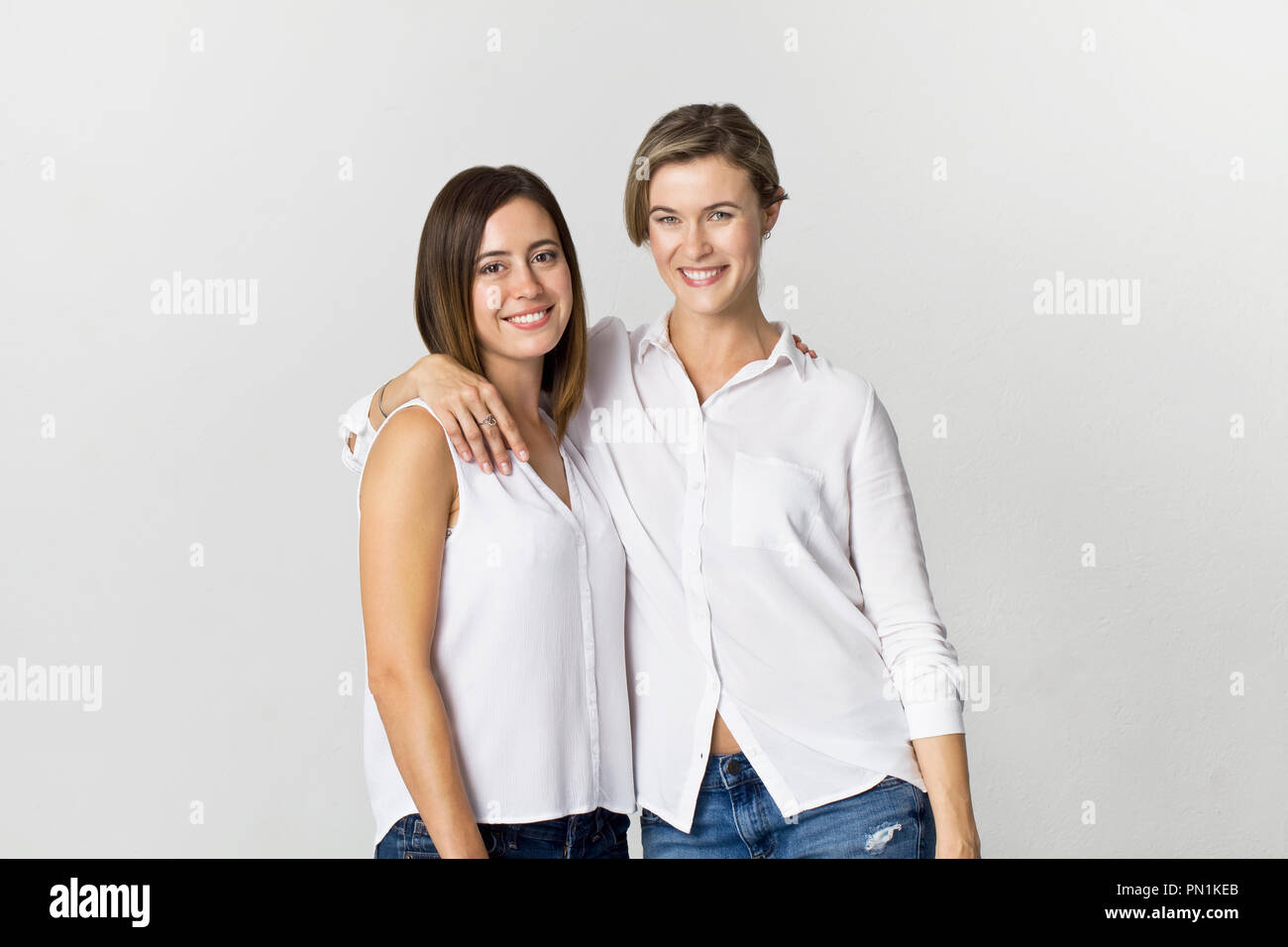 Zwei Freundinnen Spaß an Studio Hintergrund. Toothy Lächeln zwei junge Frauen portrait Stockfoto