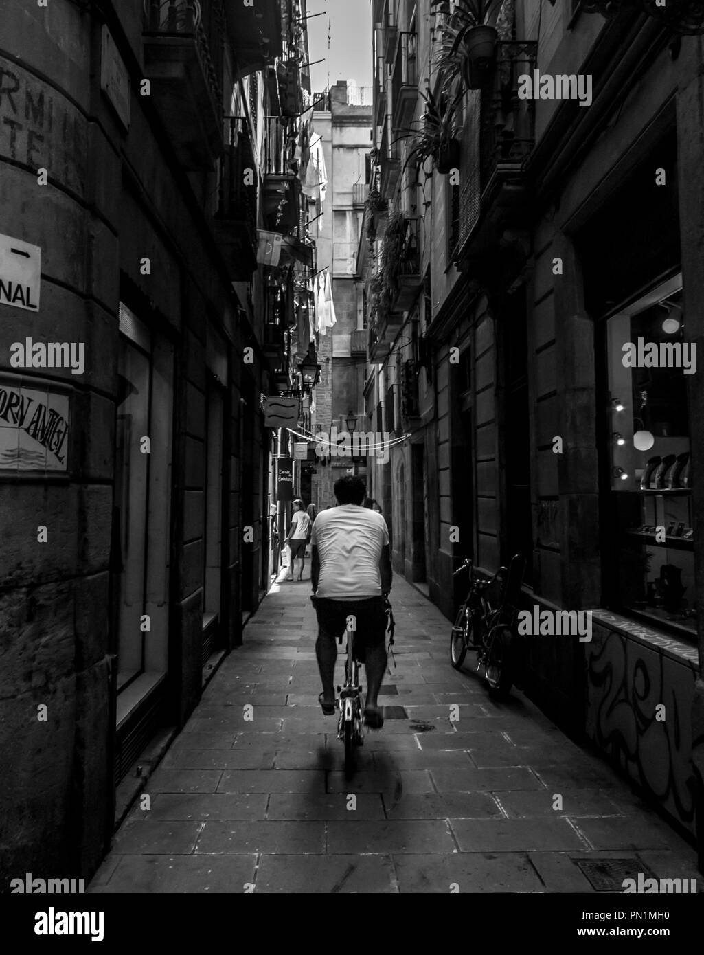Der Mensch, er reitet ein Fahrrad entlang der engen Gassen des Barri Gotic in Barcelona. Stockfoto